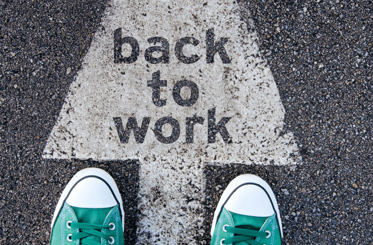 Back to work arrow on pavement with two feet ready to follow the arrow.
