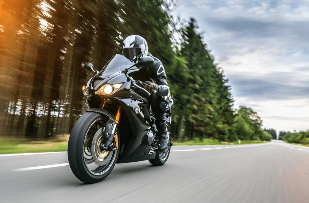 Motorcycle rider driving down an open road.