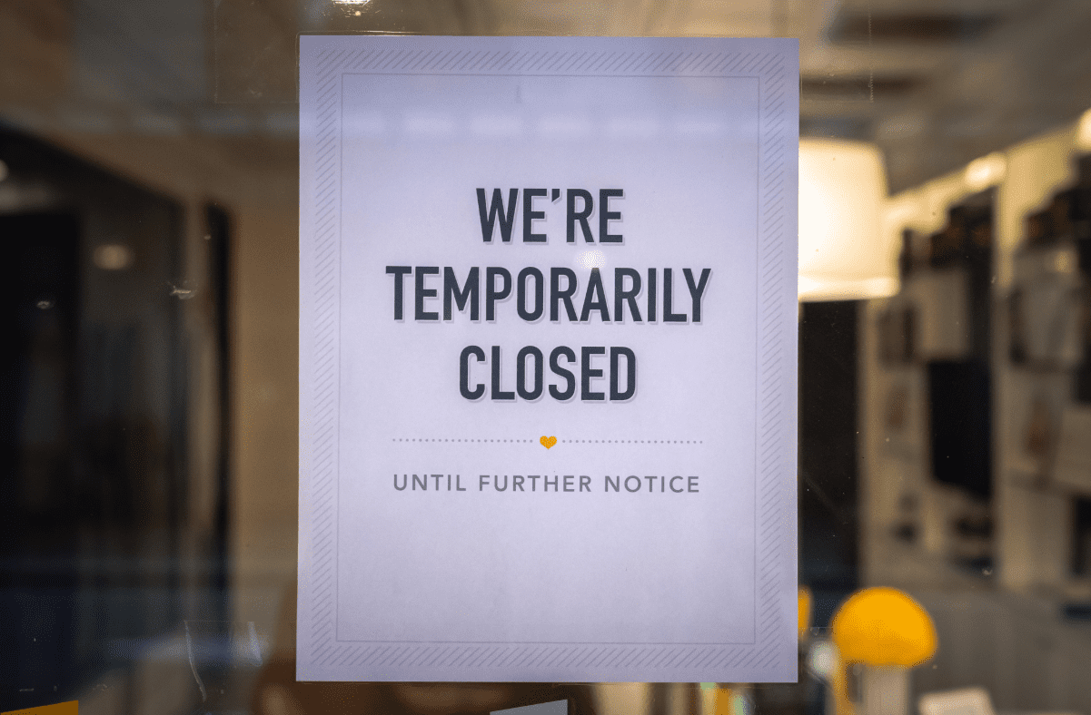 Sign on business door, "We're temporarily closed"