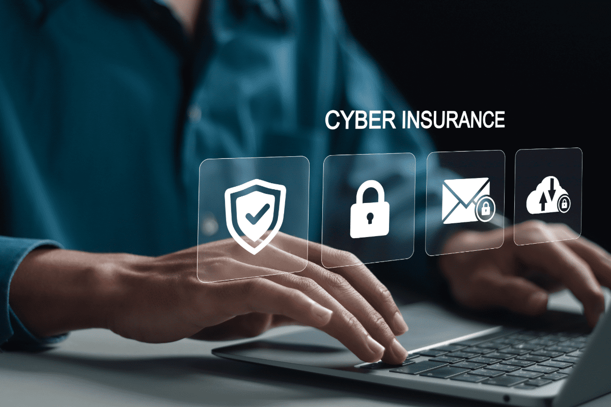 Man working on laptop computer with cyber insurance icons in foreground