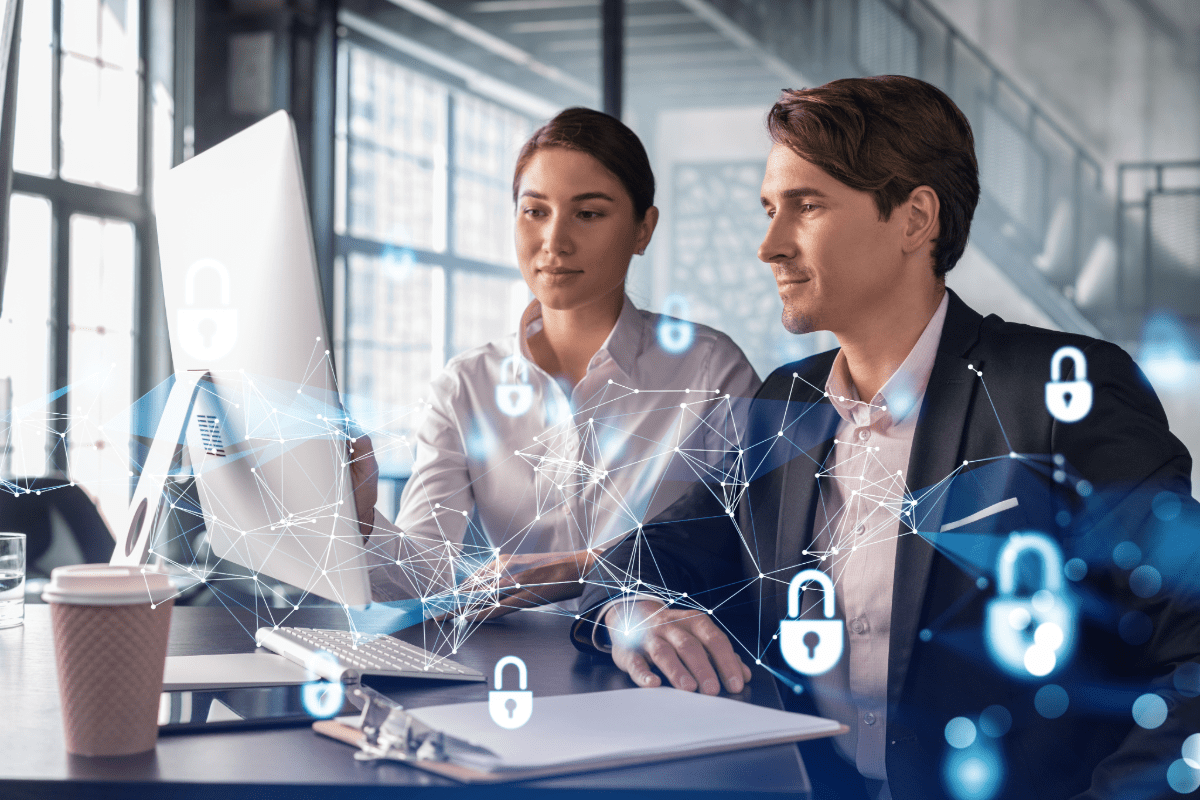 Two colleagues review information on a computer with a cyber graphic in the foreground