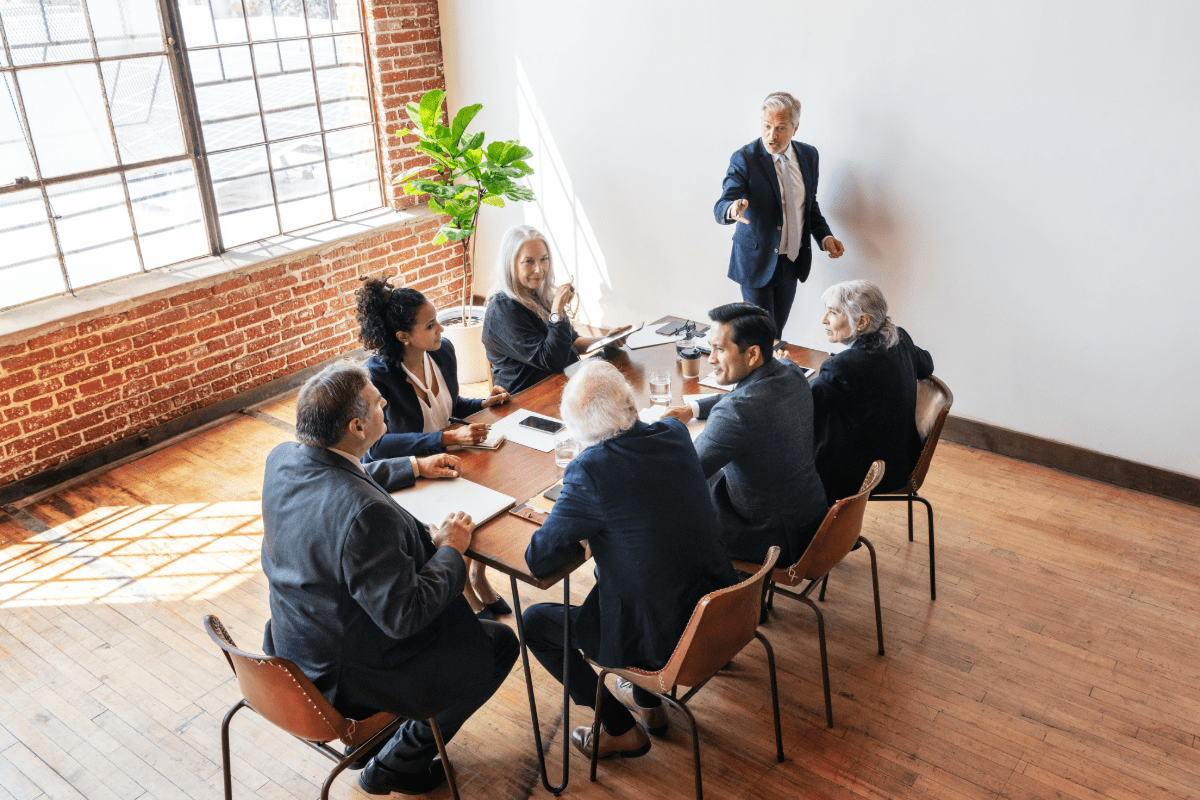 Business leaders sitting around conference table discussing directors and officers insurance for their private company