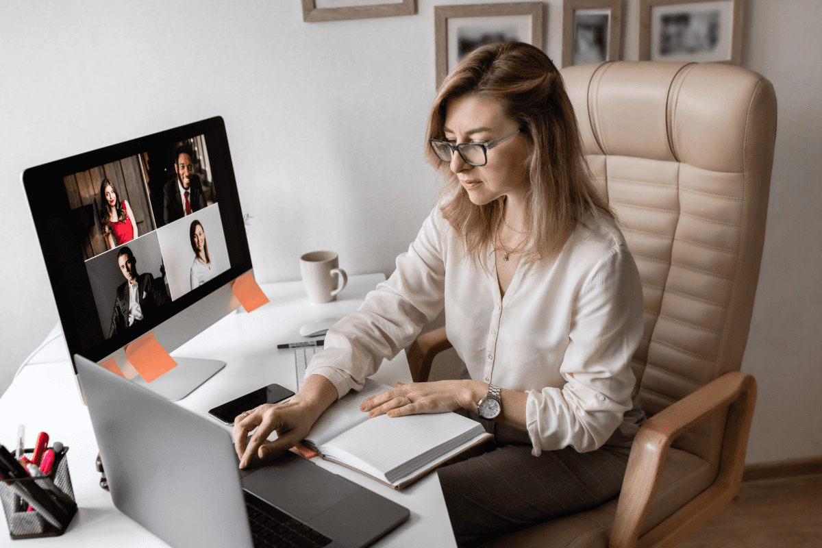 Businesswomen working remotely from home office on a Zoom meeting.