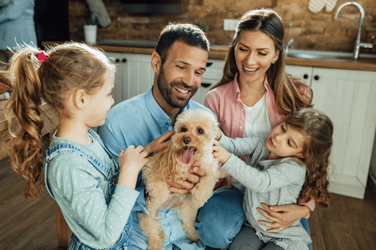 Family of four snuggling the family dog