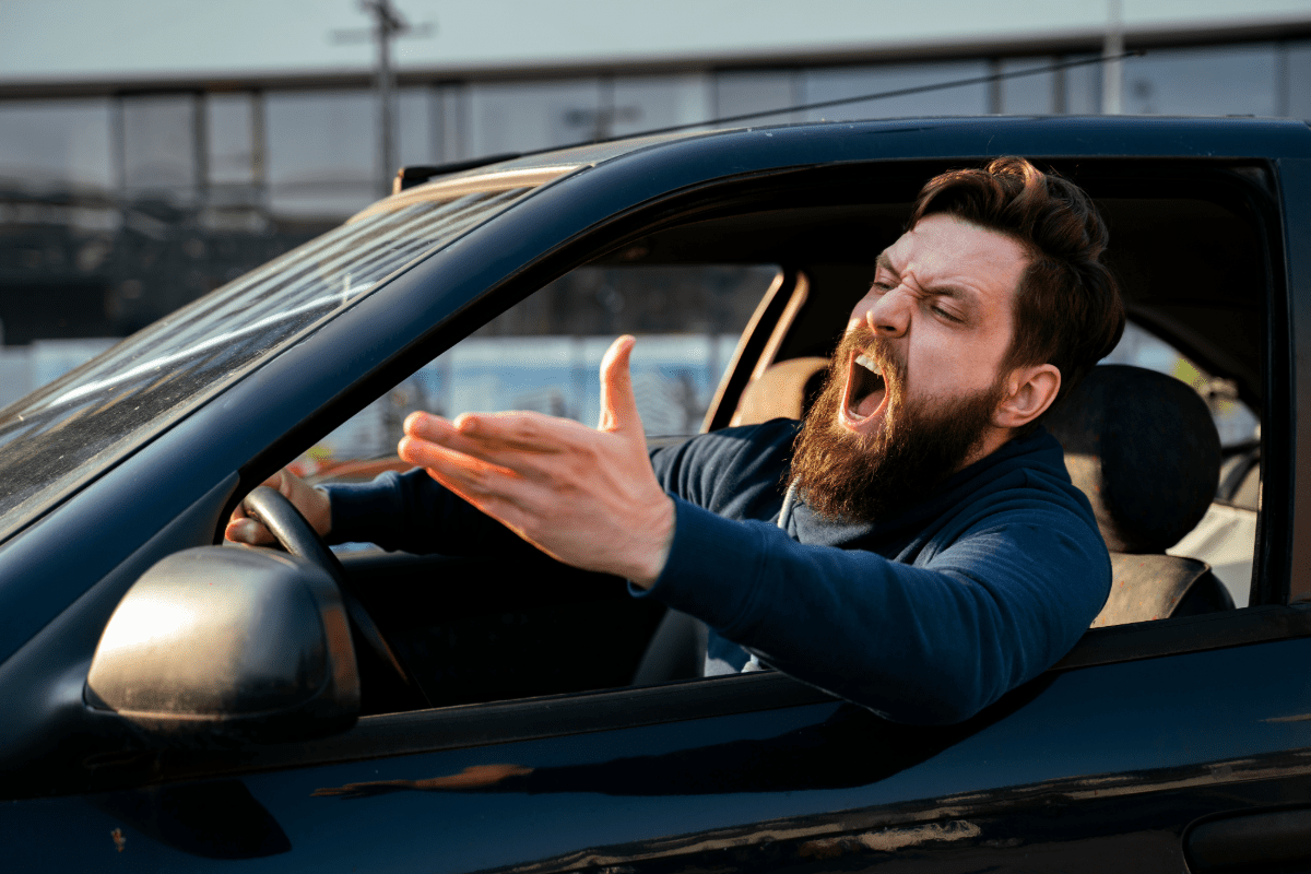 Man behind the wheel of a vehicle yelling and gesticulating