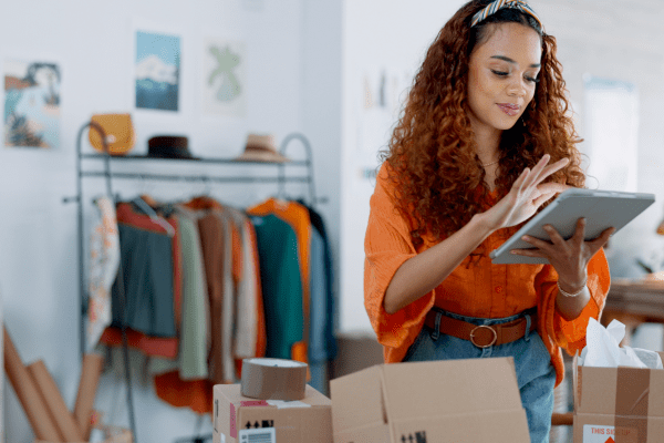 retail business owner reviewing information on tablet with store in background