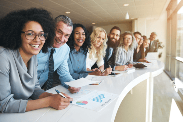 Happy employees standing along banister smiling