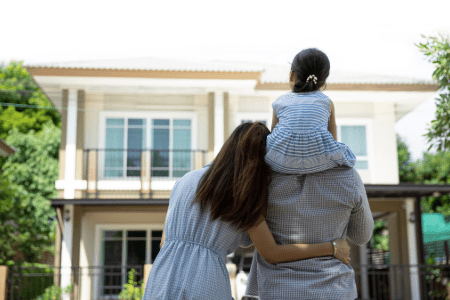 Young family standing outside new home